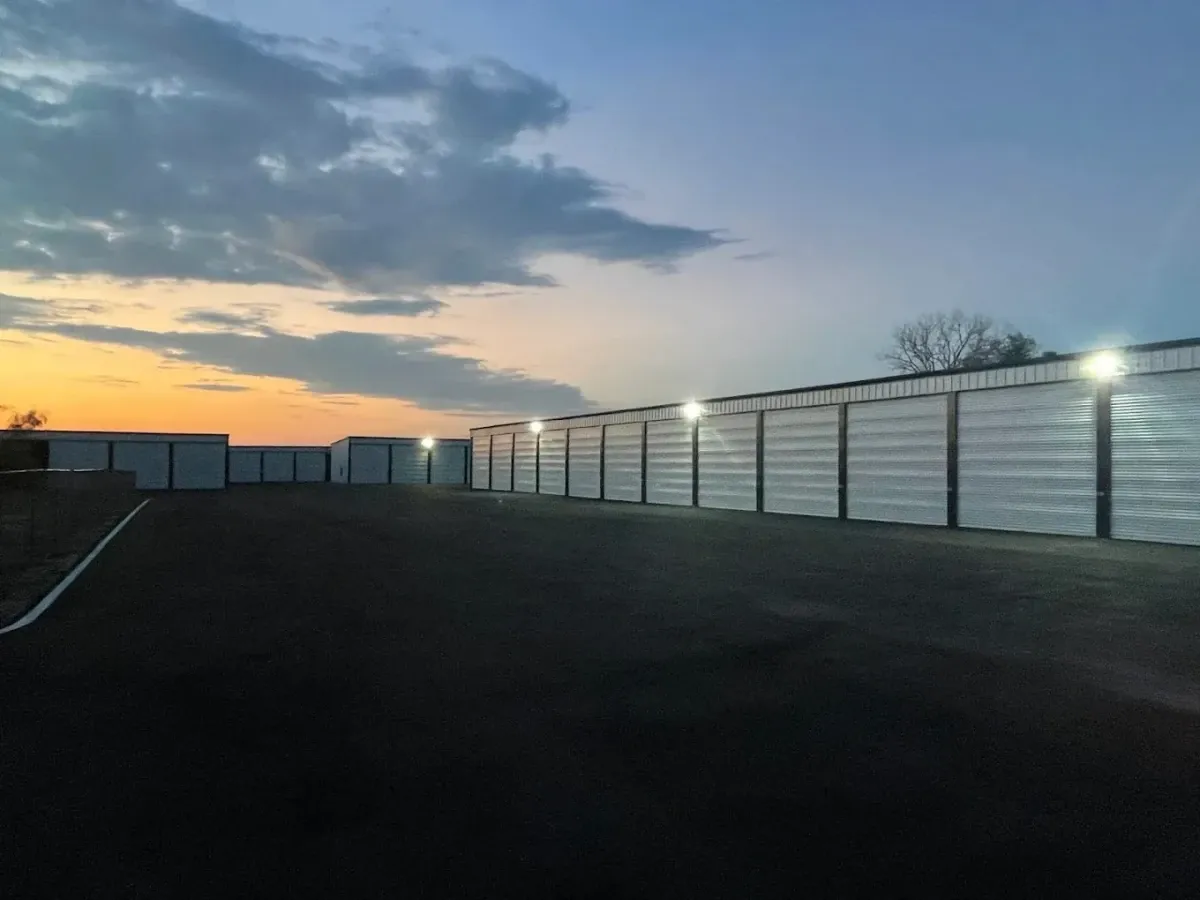 Well lit outdoor rollup storage units with paved road.